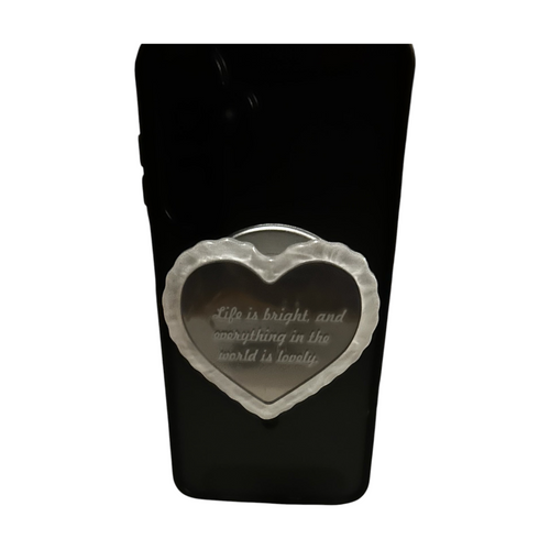 Cavalla Goods heart-shaped phone grip with a mirror finish and engraved inspirational quote on a black phone case.
